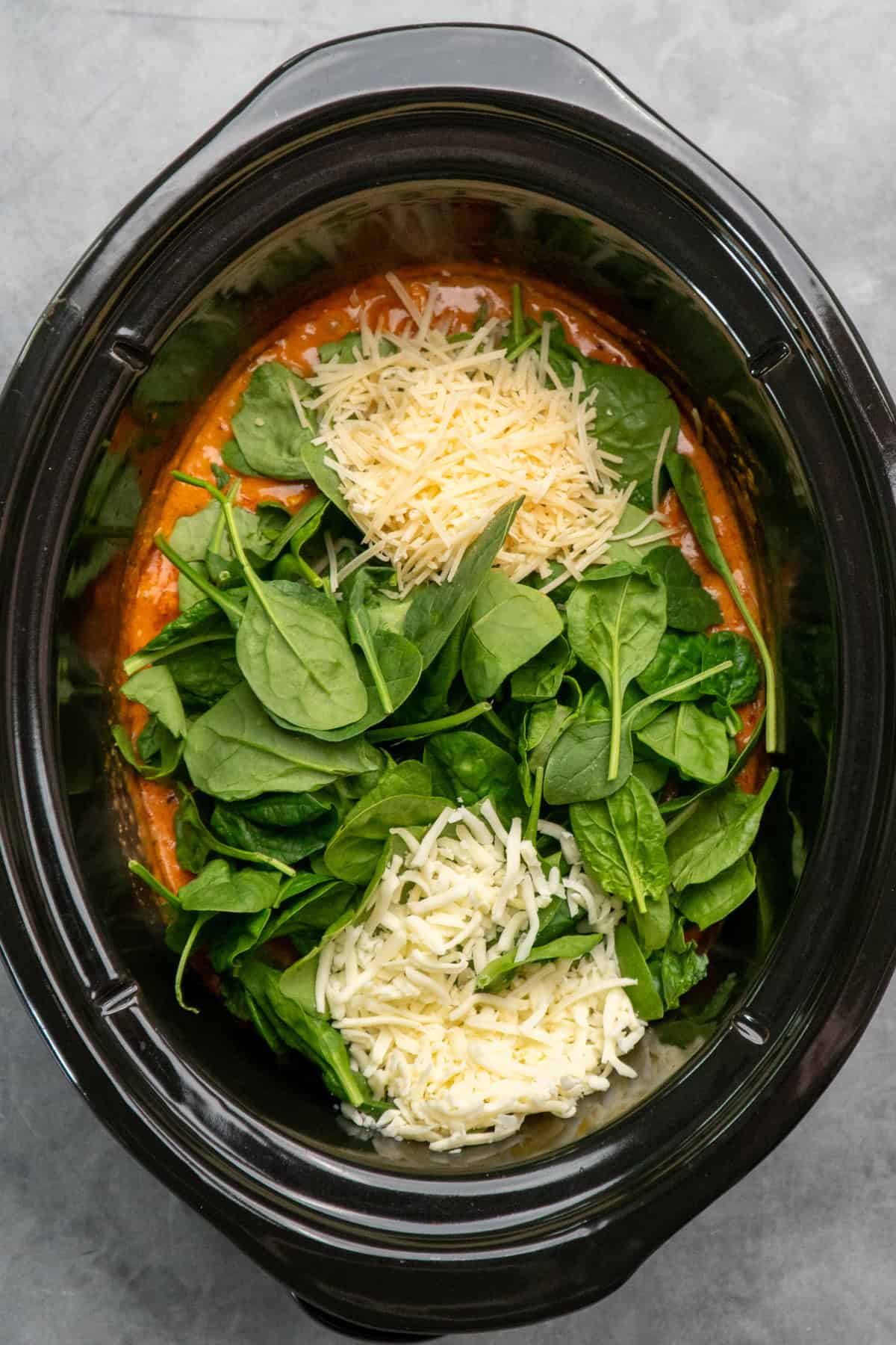 Cheese and spinach that has been add to the chicken and sauce.