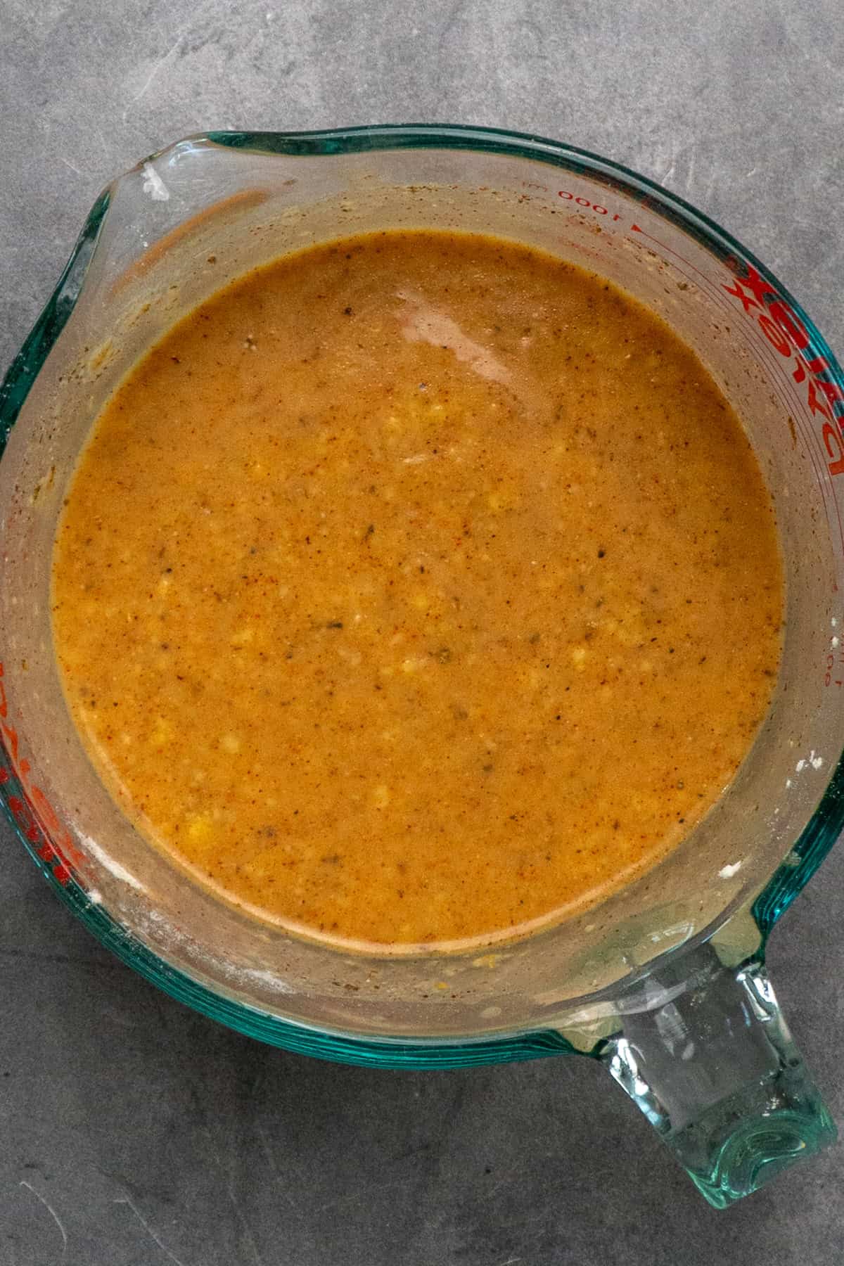 Gravy ingredients mixed together in a clear measuring cup.