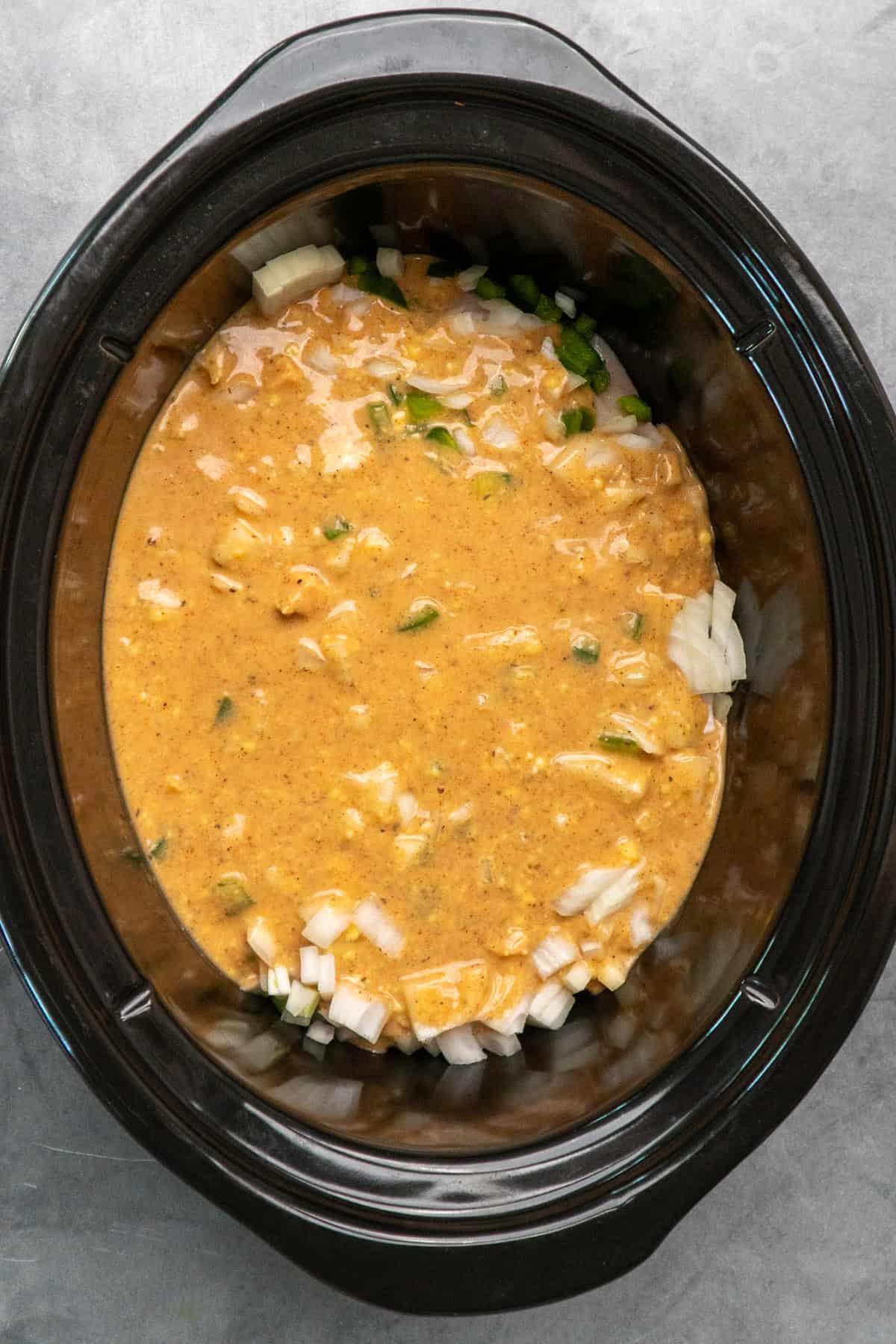 Chicken, gravy, onions and green bell peppers added to the crock pot.