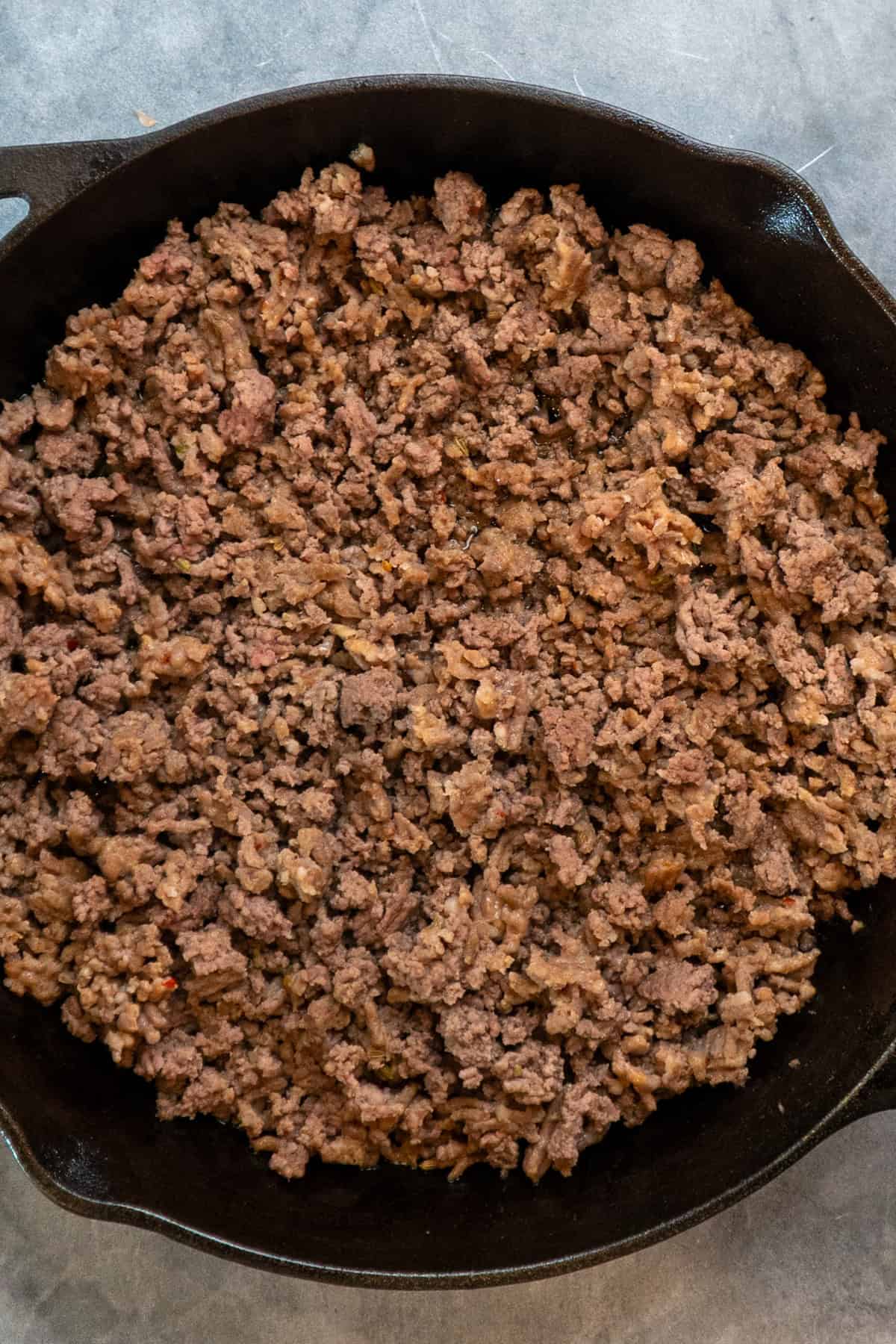Cooked ground beef and pork in a cast iron skillet.