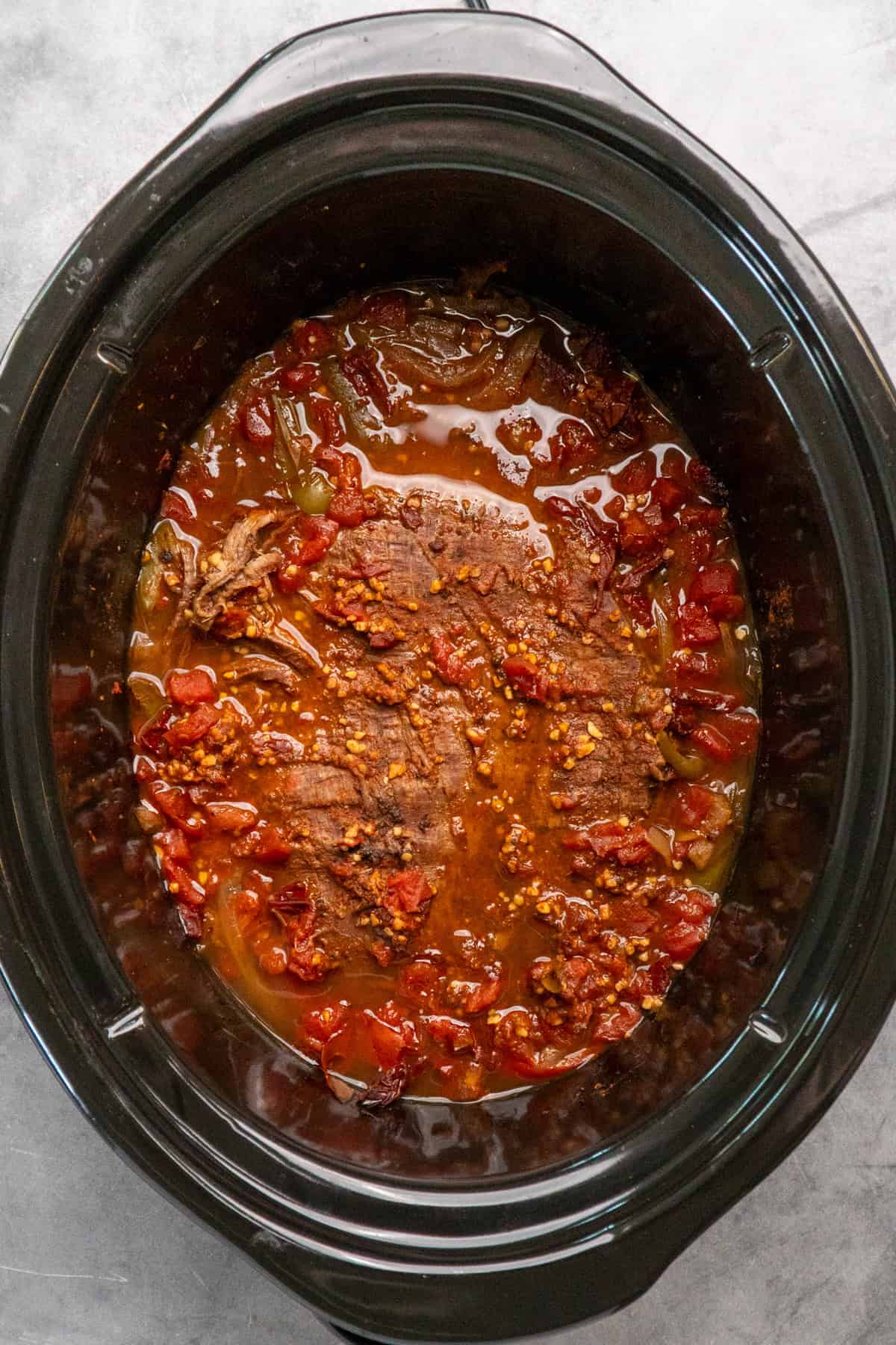 Cooked steak fajitas in a slow cooker.