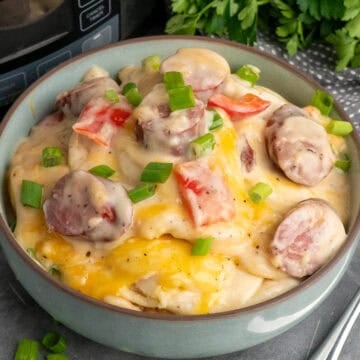 Crock pot pierogi casserole in a blue bowl and garnished with green onions.
