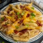 Crock pot crack chicken pasta on a plate topped with green onions.