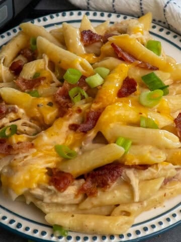 Crock pot crack chicken pasta on a plate topped with green onions.