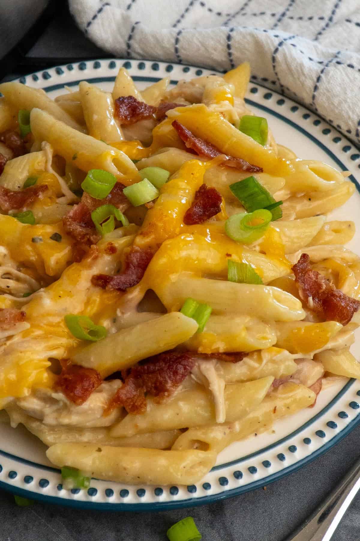 Crock pot crack chicken pasta on a plate topped with green onions.