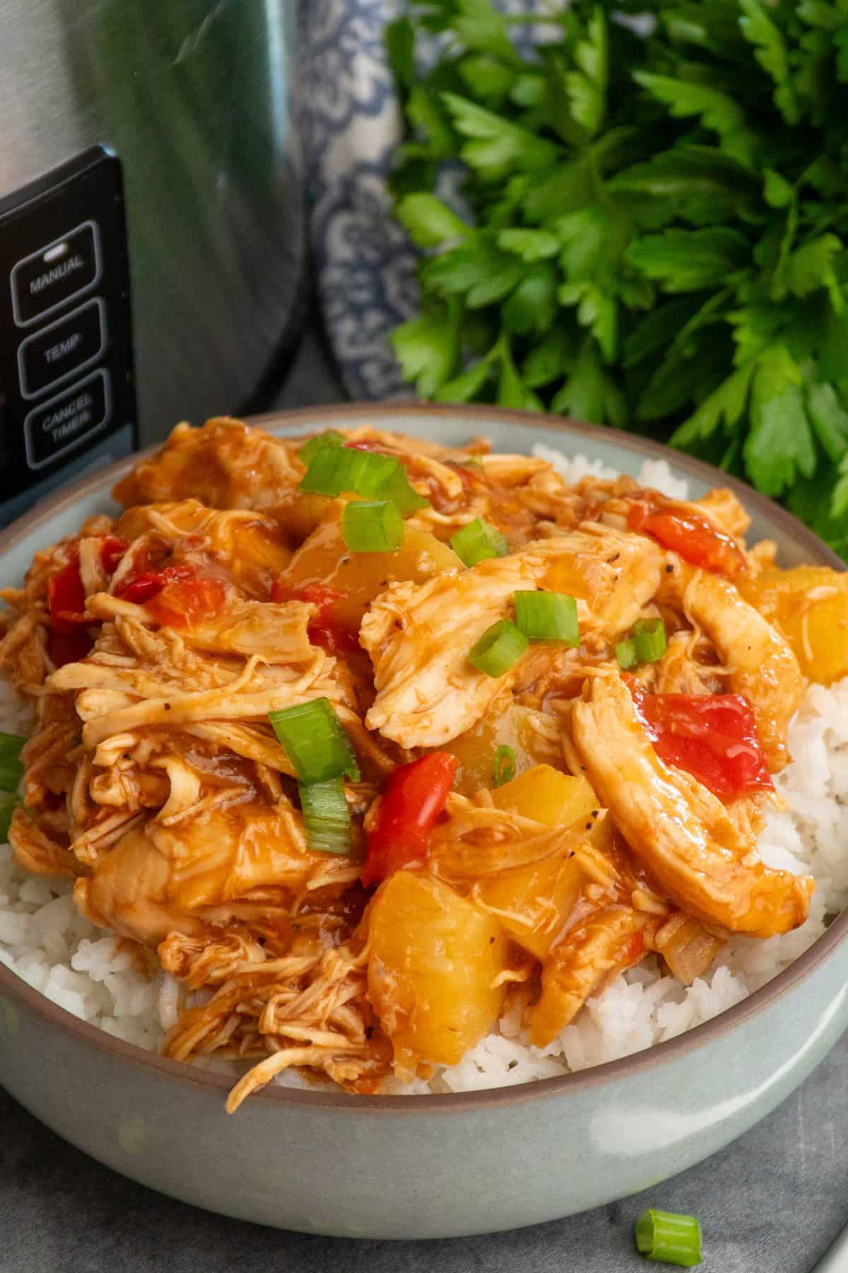 Crock pot pineapple BBQ chicken over a bowl of rice.