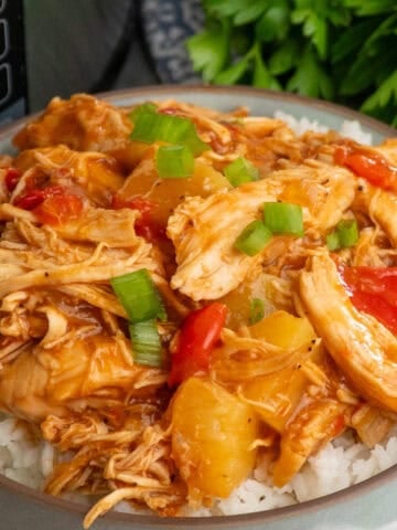 Crock pot pineapple BBQ chicken over a bowl of rice.