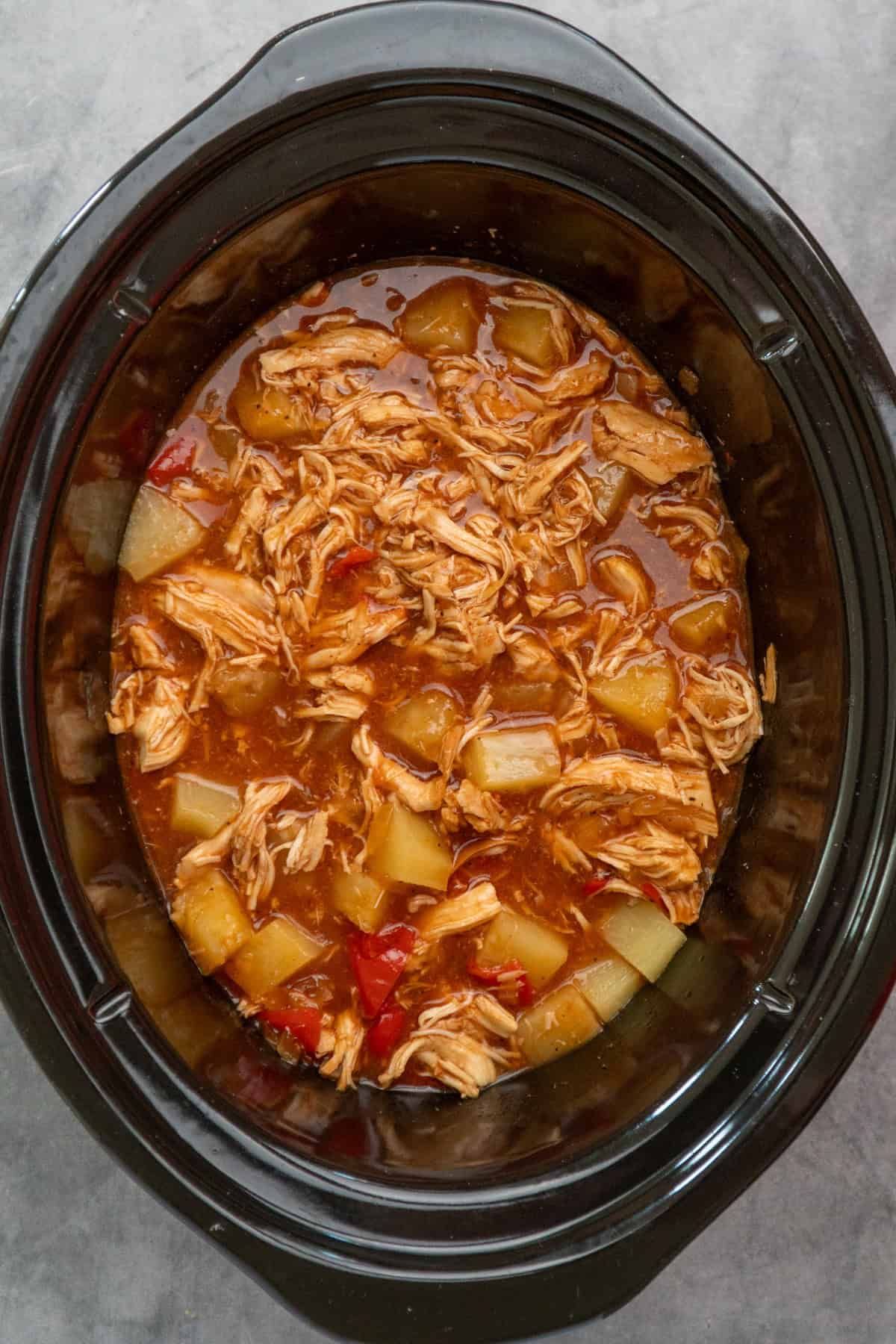 Shredded chicken and pineapple added to the crock pot.