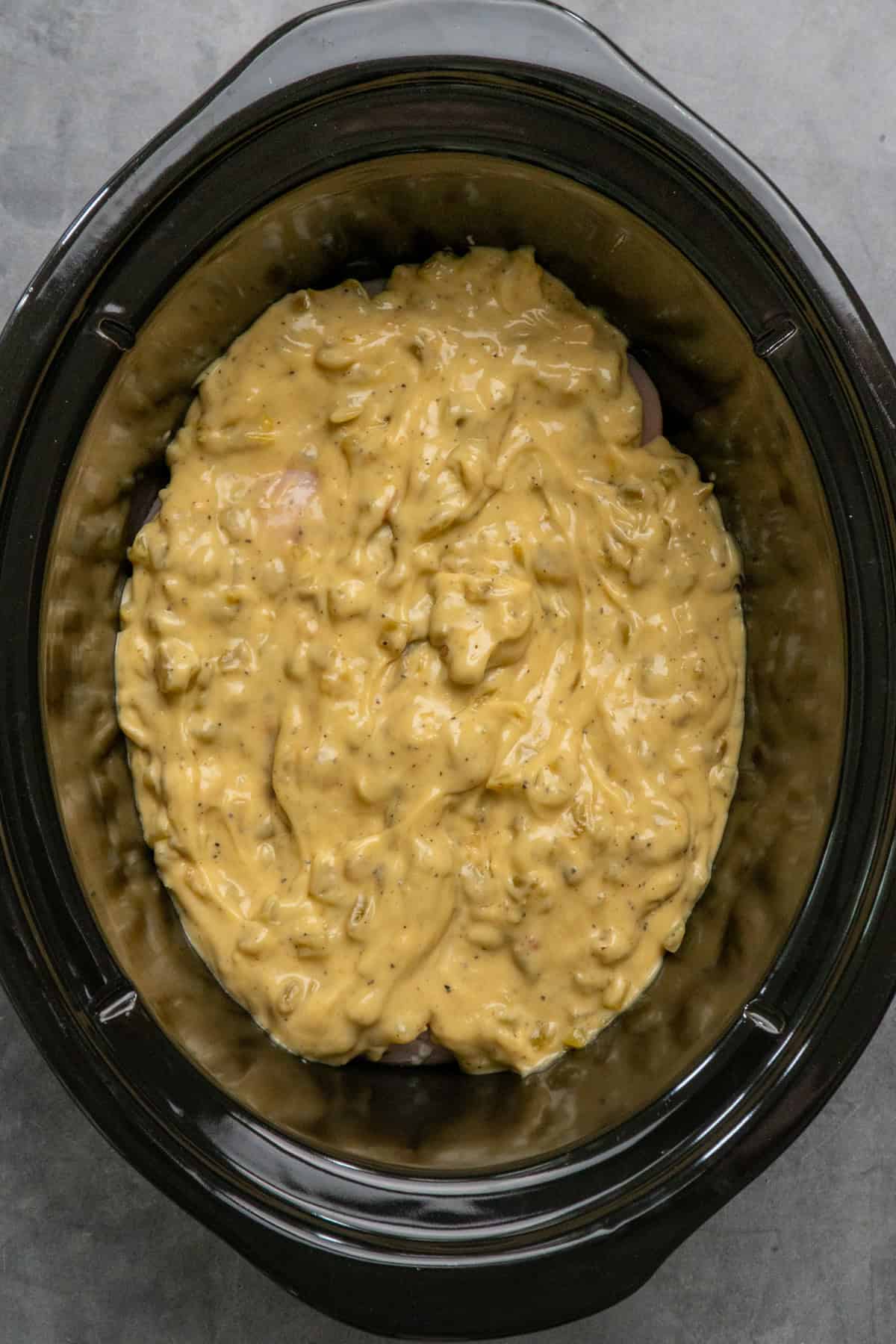 Green chile chicken sauce over chicken and ready to cook.