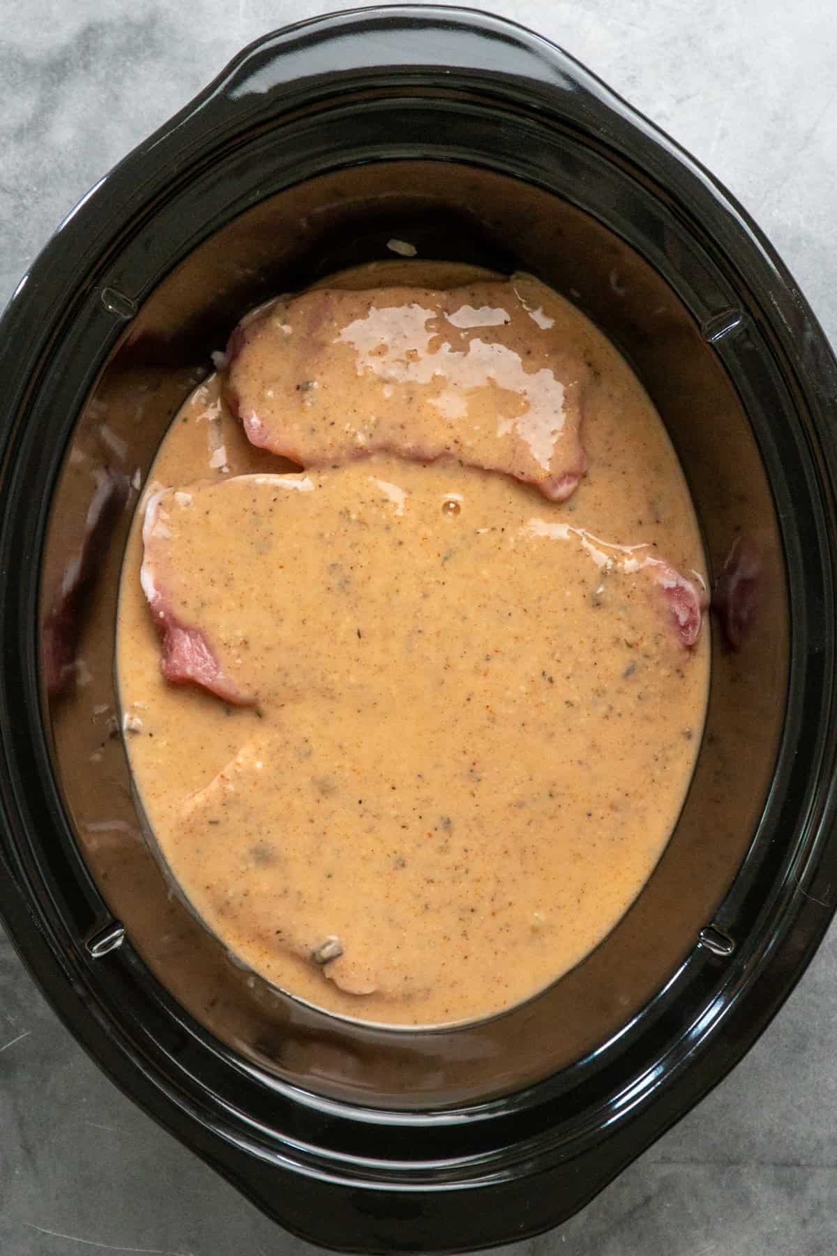 Sauce poured over pork chops and ready to cook.