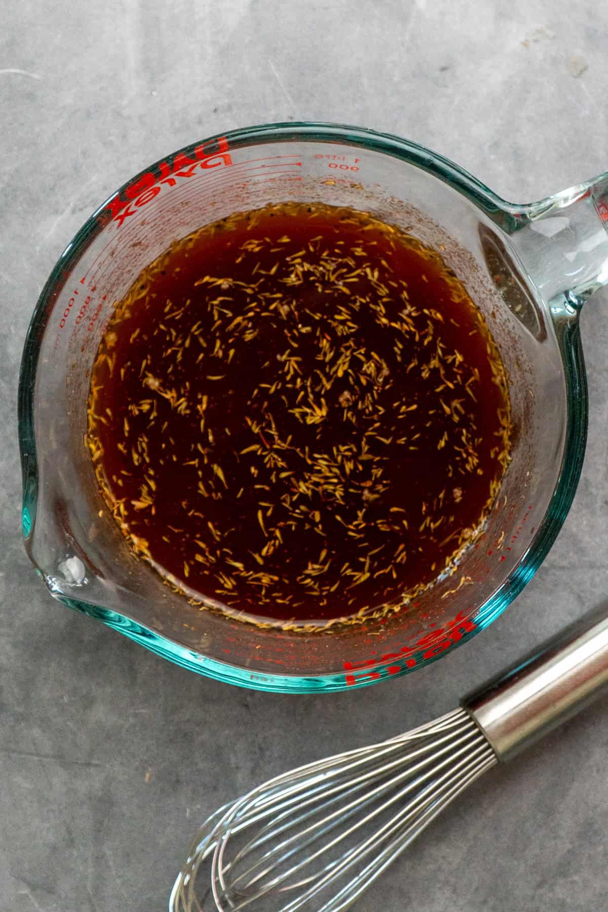 Gravy ingredients mixed together in a glass measuring cup.