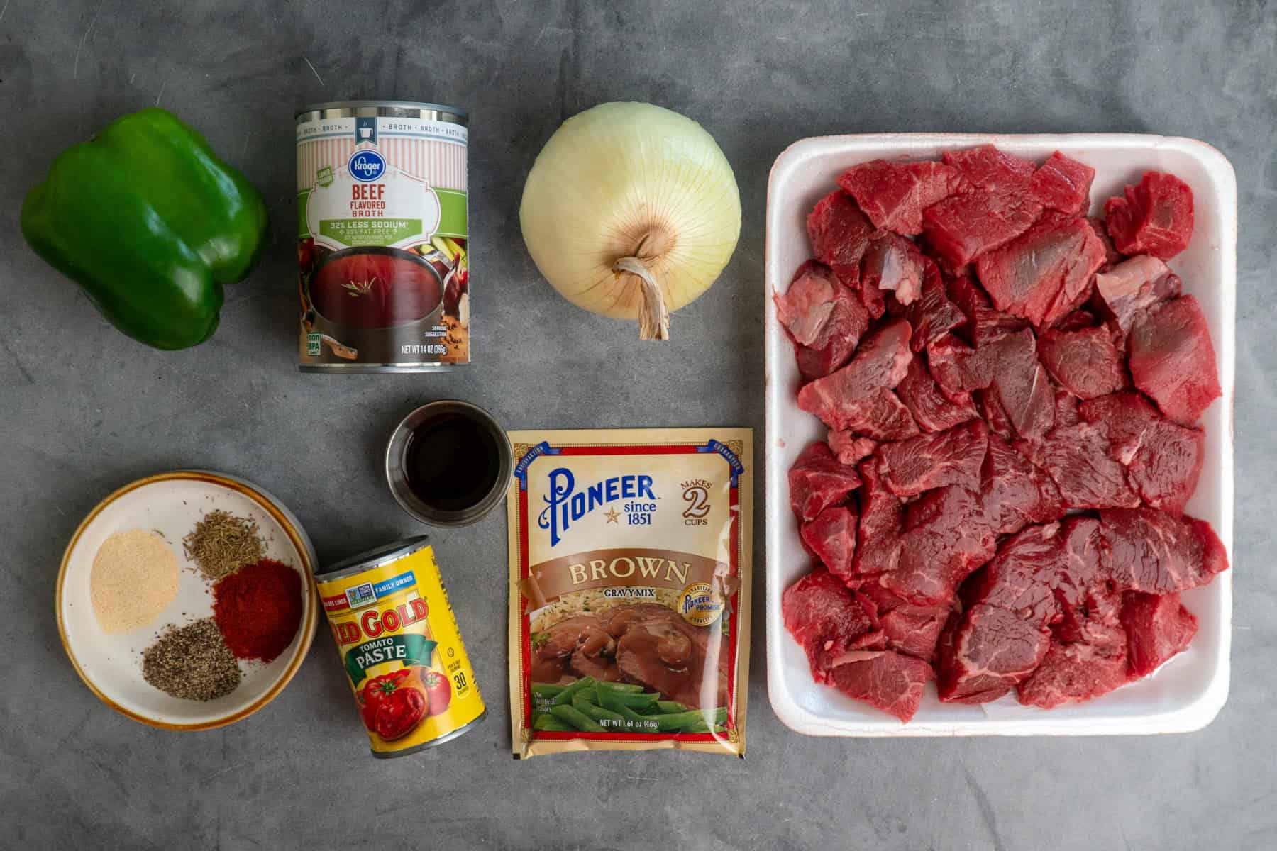 Ingredients to make steak and gravy on a gray stone countertop.