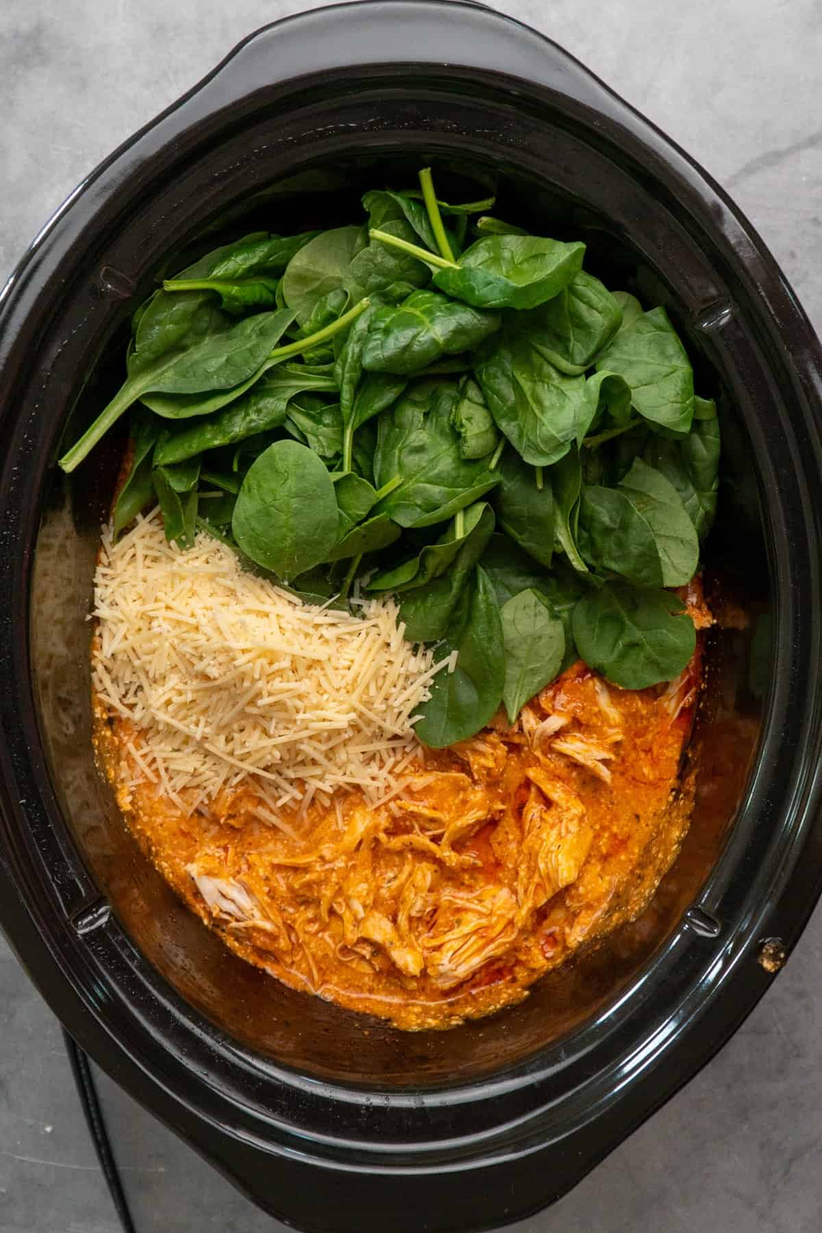 Parmesan cheese and spinach added to the shredded chicken.