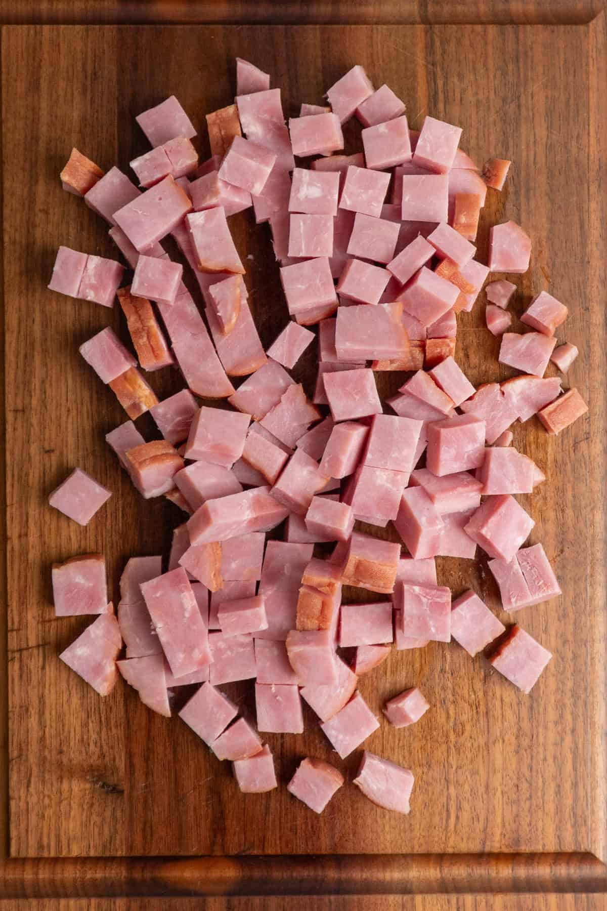 Chopped ham on a wood cutting board.
