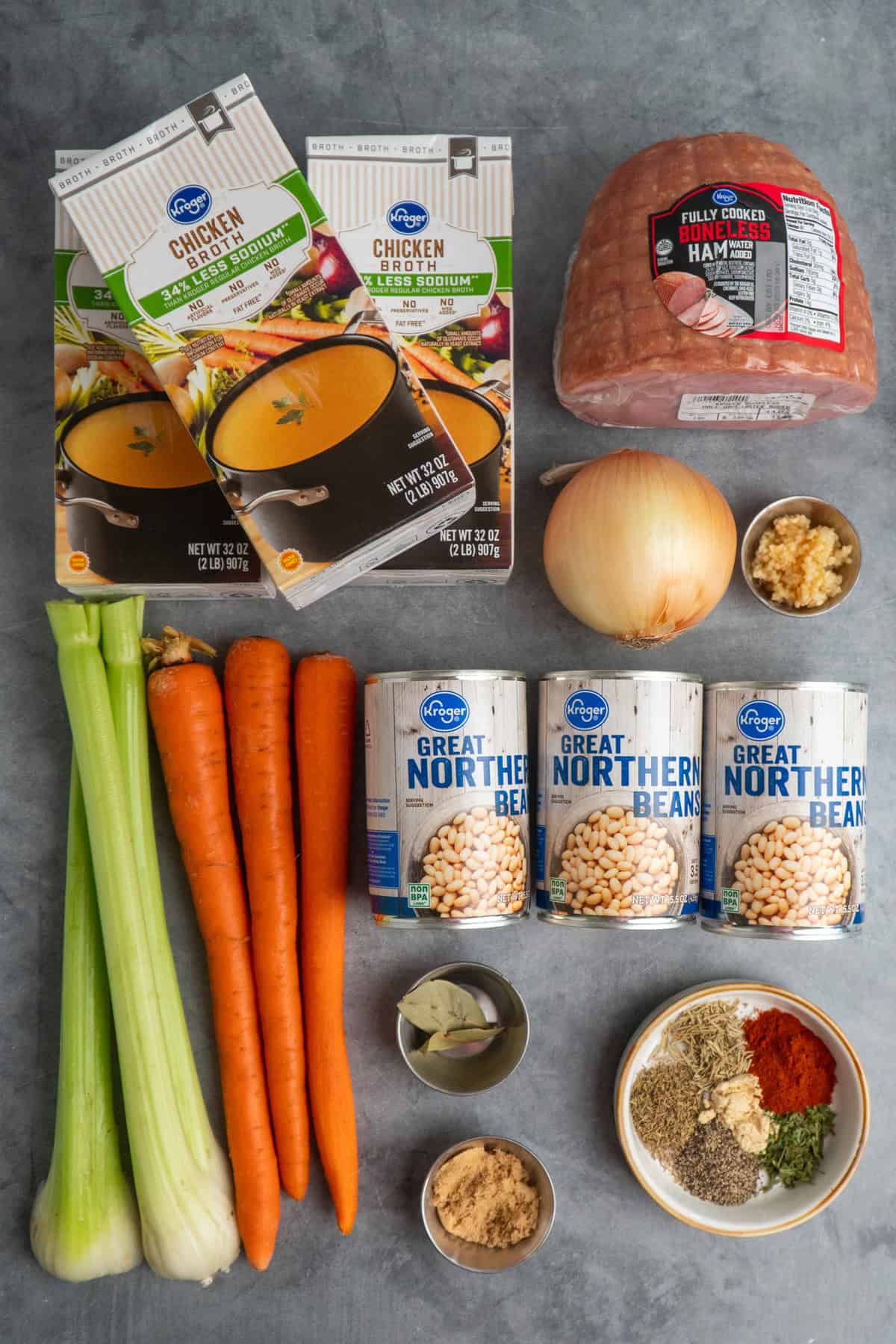 Ingredients to make ham and bean soup on a gray countertop.