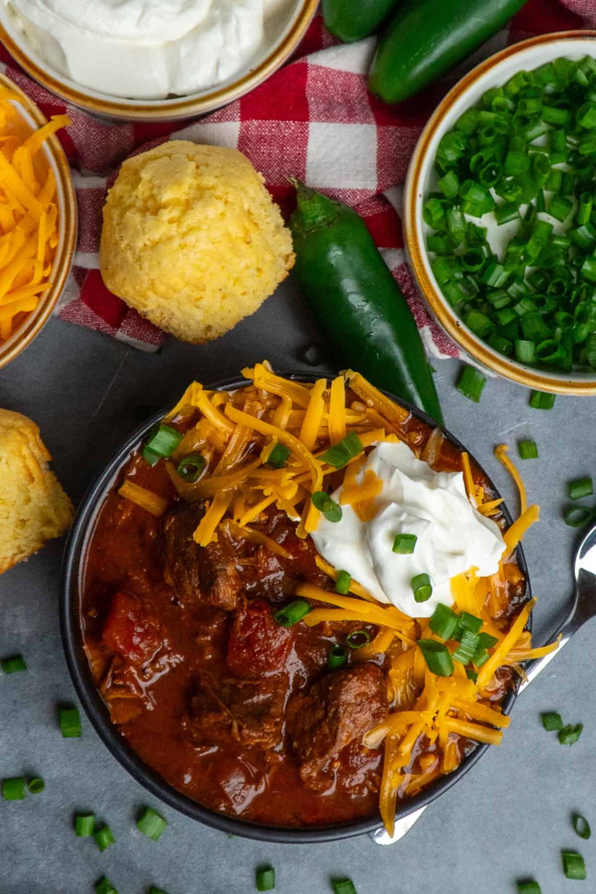 Slow Cooker Texas chili in a bowl and topped with grated cheese and sour cream.