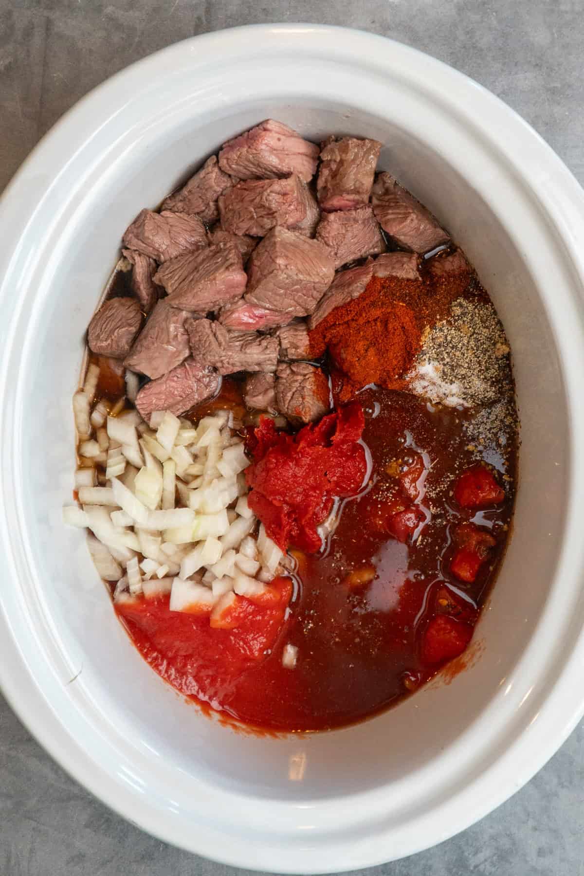 Ingredients for Texas chili in a slow cooker.