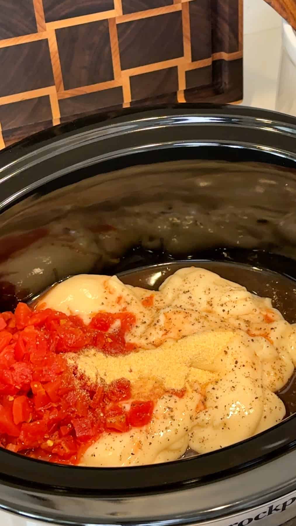 Cheese soup, Rotel, and seasonings added to the slow cooker.