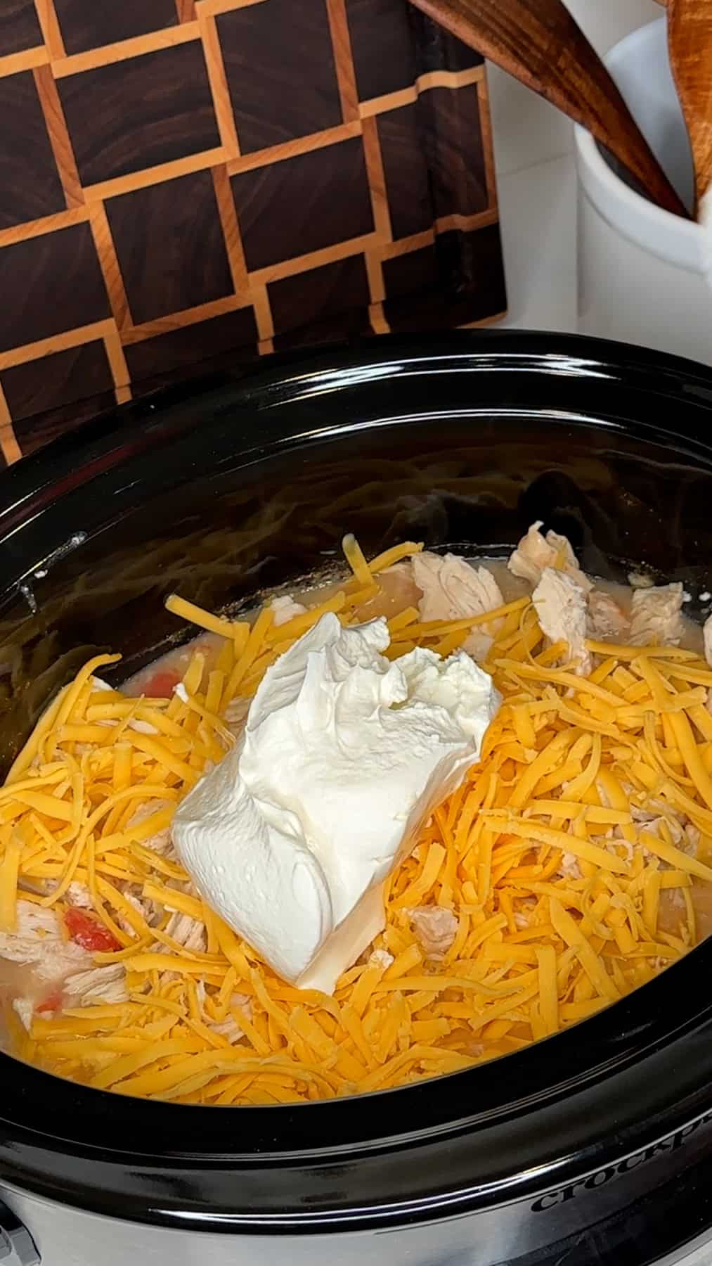 Shredded chicken, cheese and cream cheese add to the crock pot.