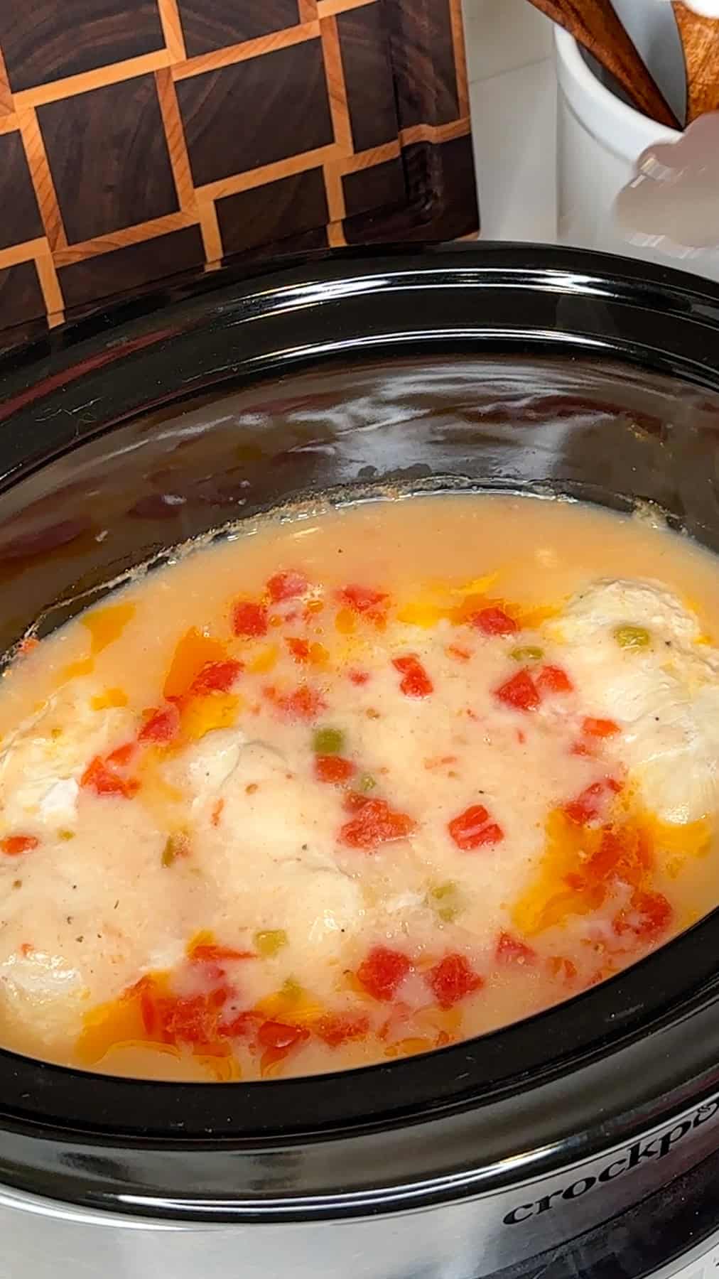 Cheesy chicken cooked in a crock pot ready to be shredded.
