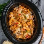Crock Pot Italian sausage pasta with melted cheese on top.