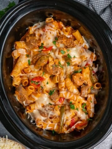 Crock Pot Italian sausage pasta with melted cheese on top.