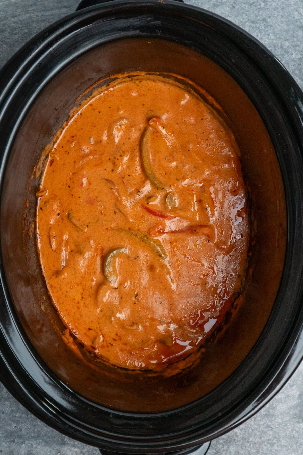 Cooked vegetables and sausage in a crock pot.