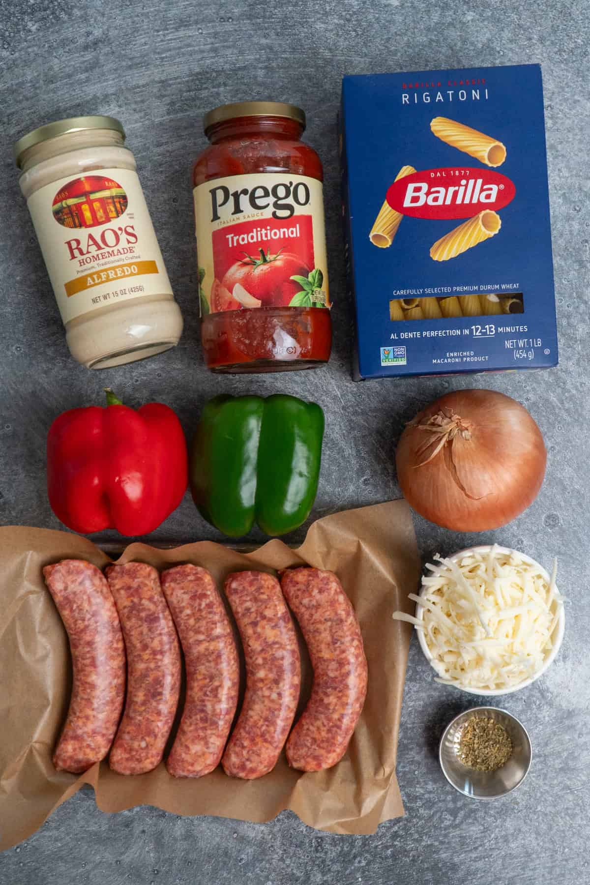 Ingredients to make Italian sausage pasta on a gray countertop.