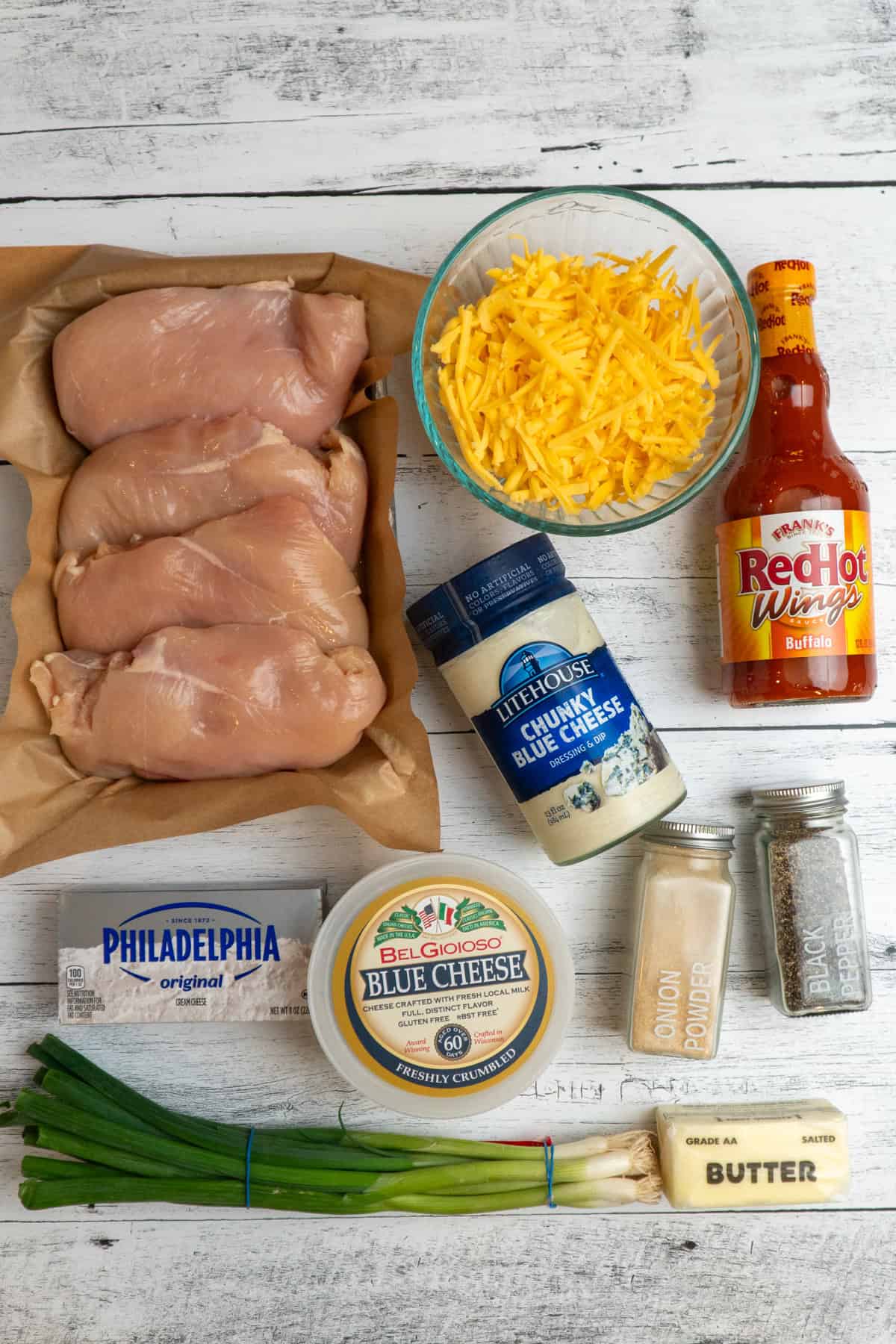 Ingredients to make buffalo chicken dip on a white wood countertop.