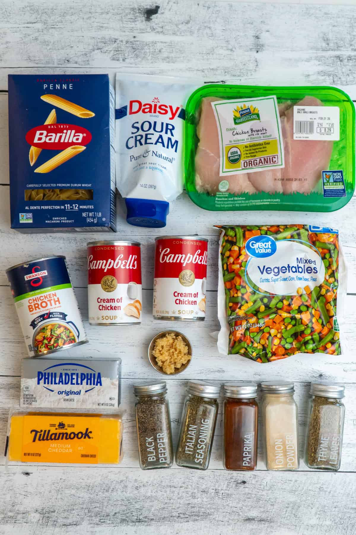 Ingredients to make chicken pot pie pasta in the crockpot on a table.