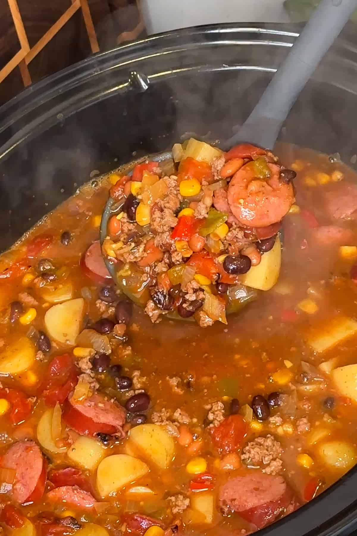 A ladle holding a scoop of cowboy soup.