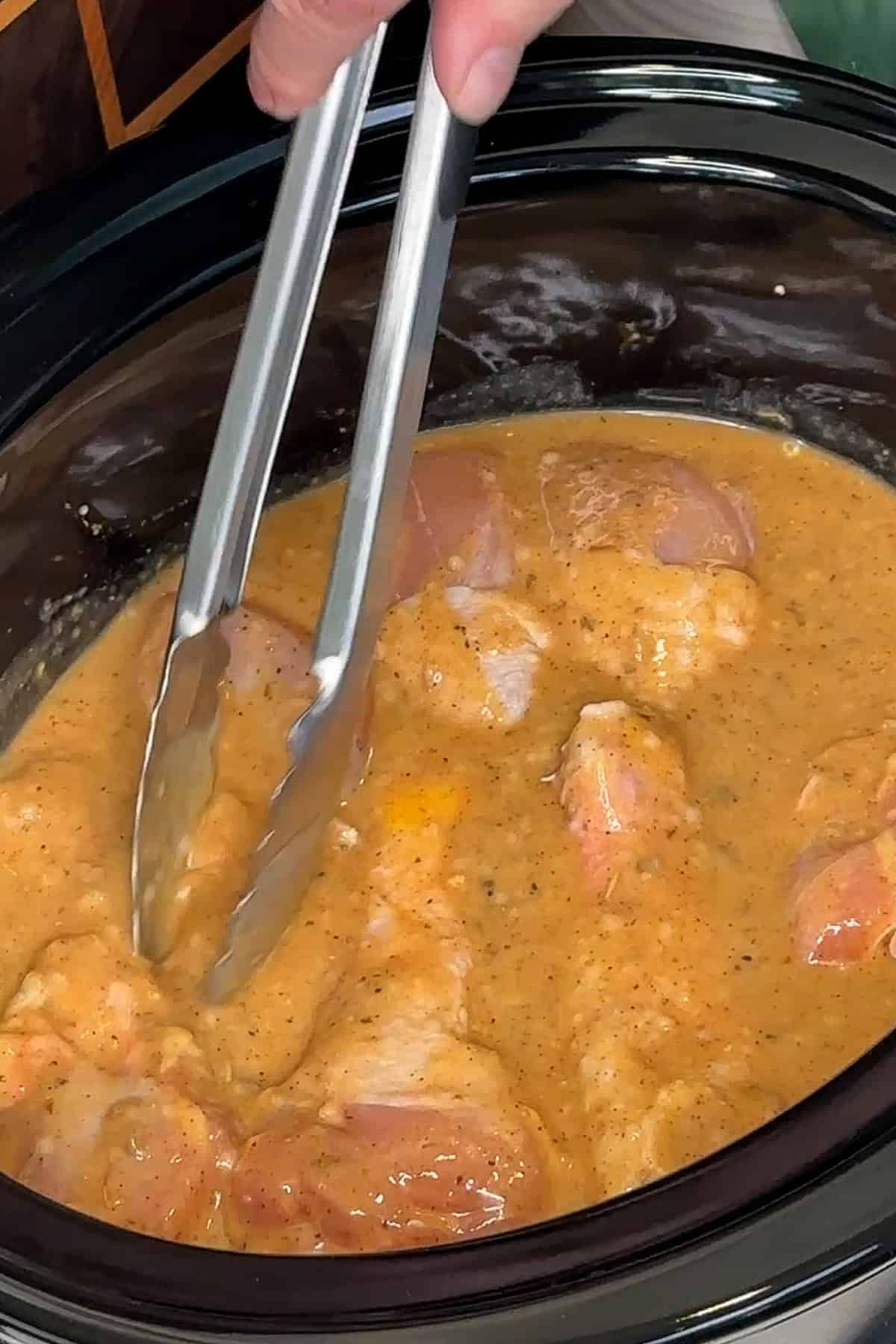 Chicken legs tossed and coated in the prepared sauce.