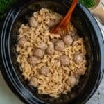 Crock Pot Swedish meatballs with a wooden spoon in it ready to be served.
