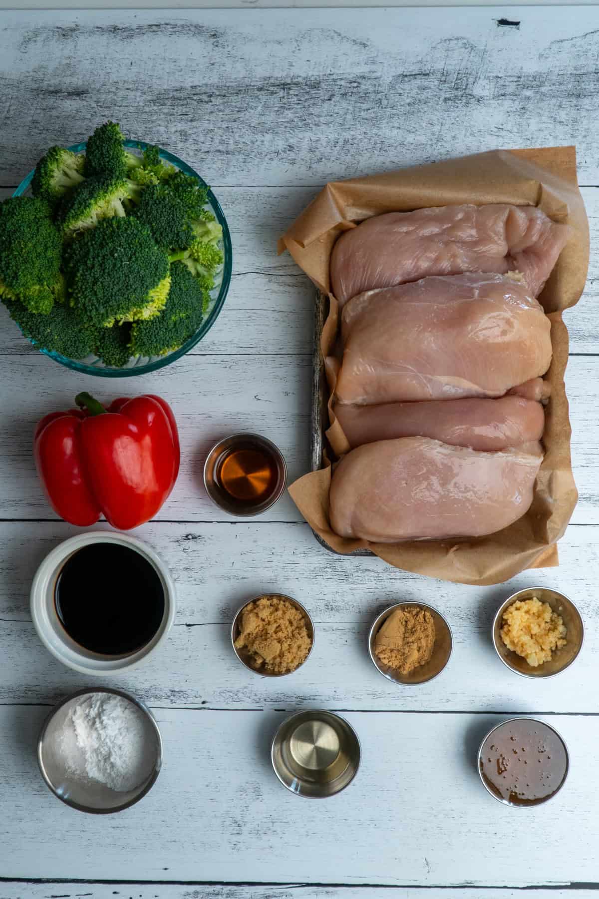 Ingredients to make teriyaki chicken on a white wood countertop.