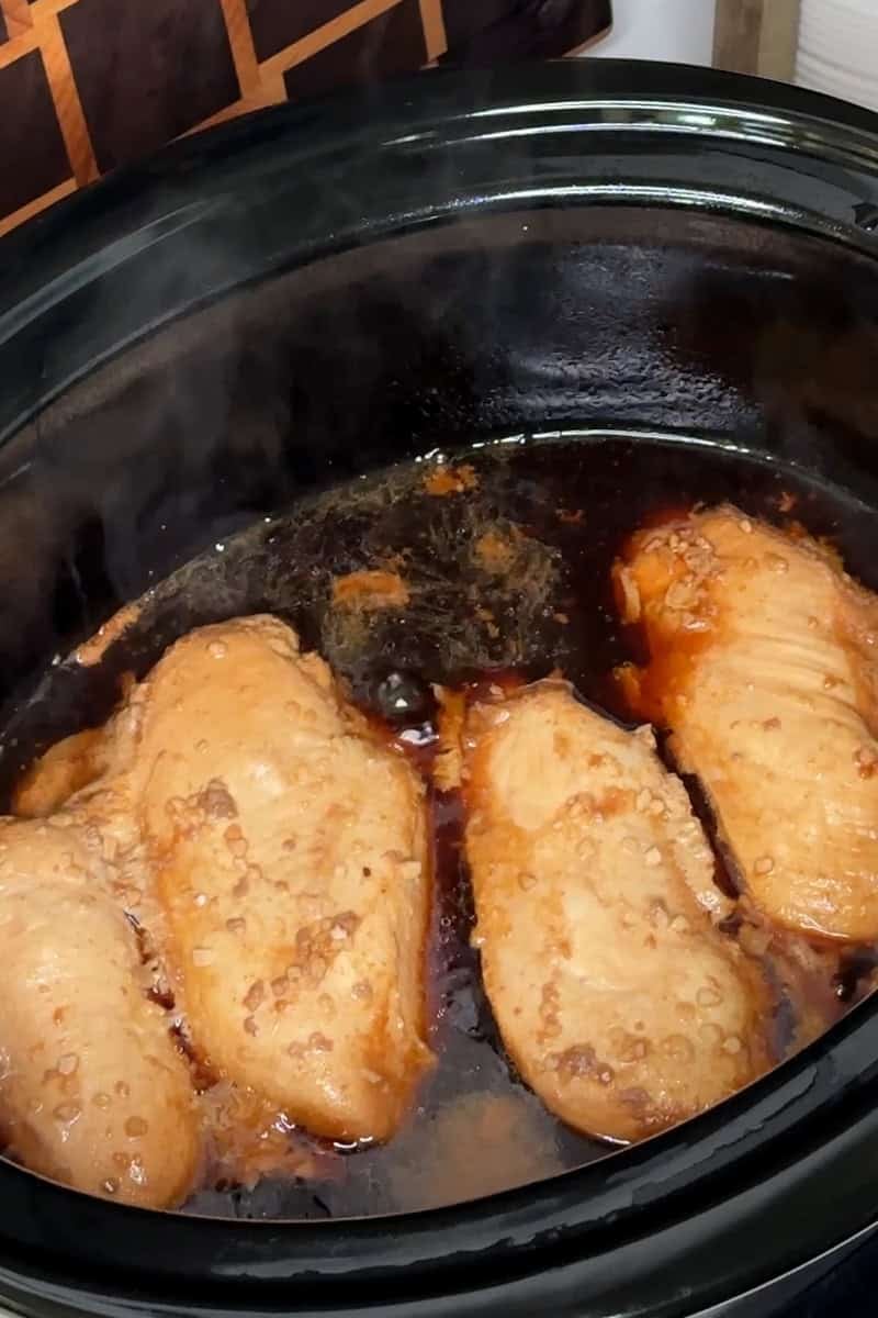 Four chicken breasts that has been cooked in teriyaki sauce.