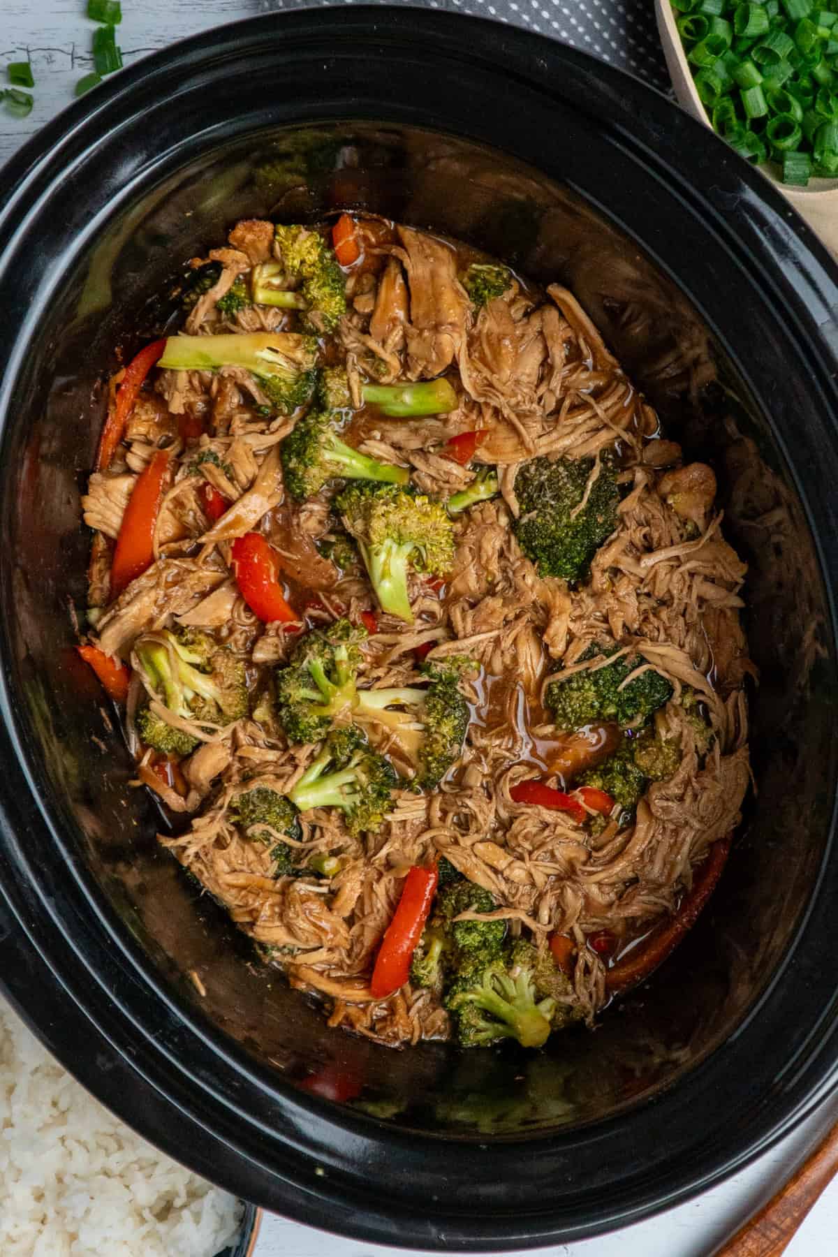 Crock Pot teriyaki chicken with a side of rice and green onions.