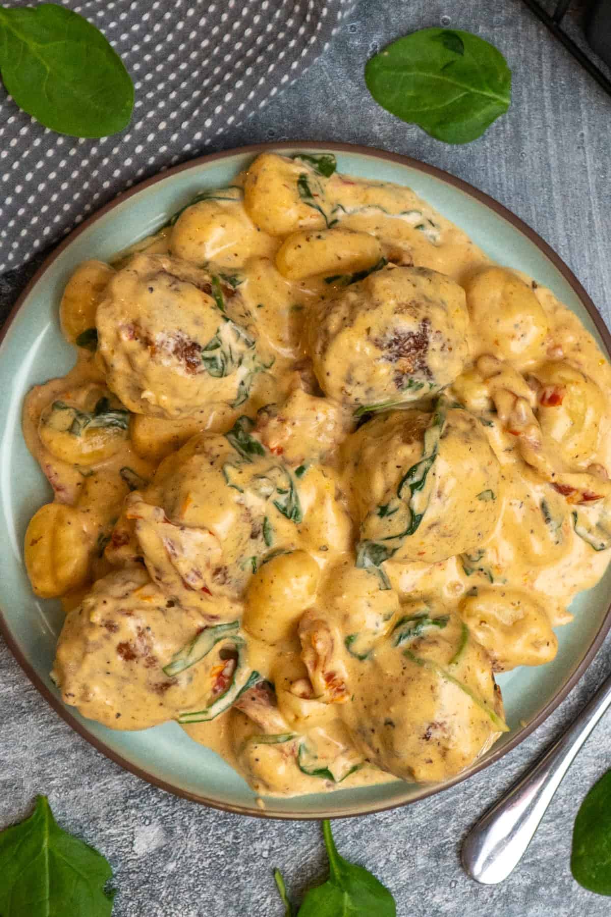 Tuscan chicken meatballs and gnocchi on a plate.