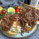 Beef Manhattan over a plate of Texas toast and mashed potatoes.