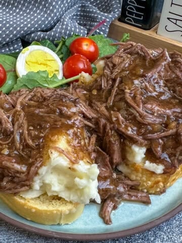Beef Manhattan over a plate of Texas toast and mashed potatoes.