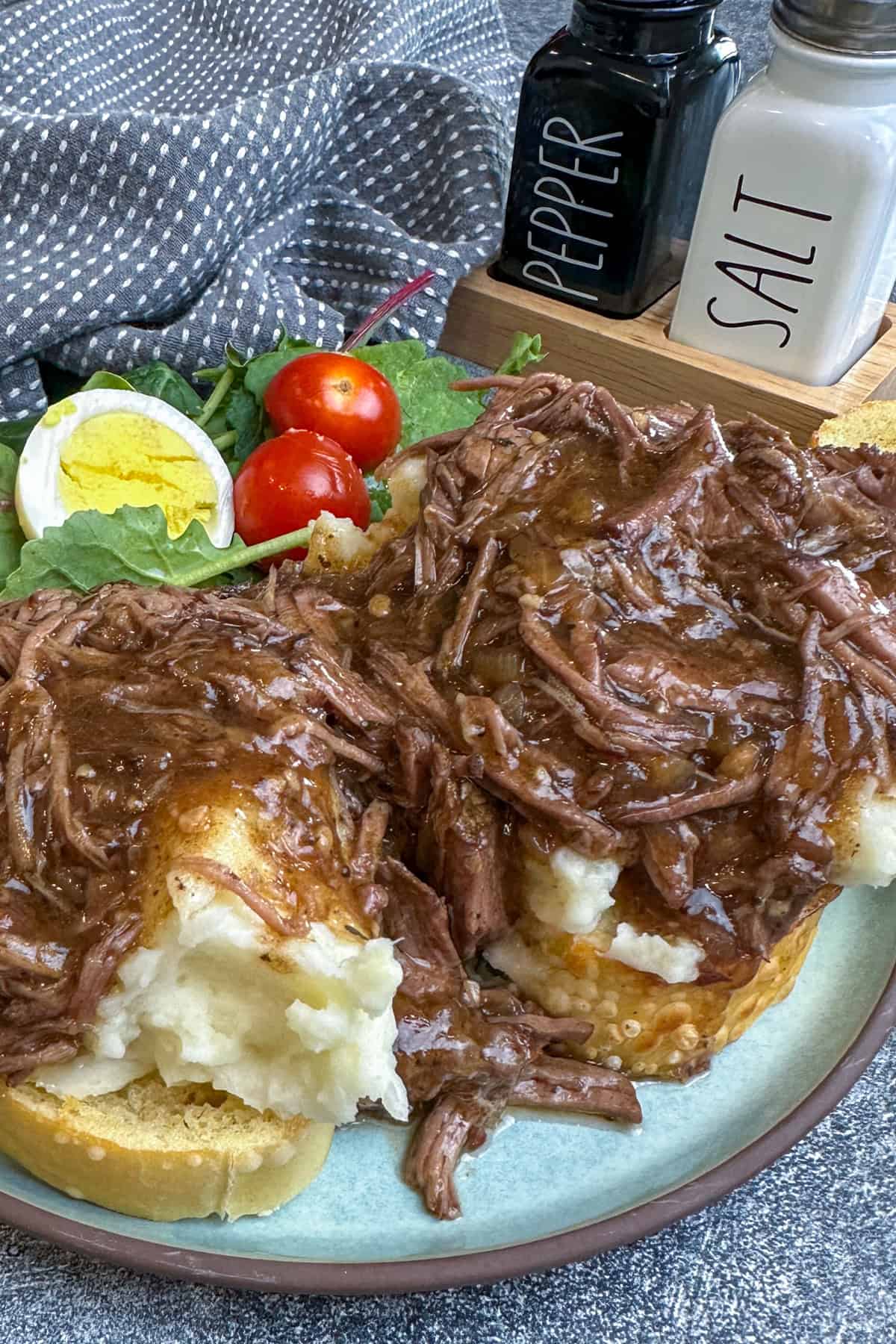 Beef Manhattan over a plate of Texas toast and mashed potatoes.