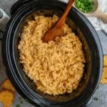 Crock pot buffalo chicken mac and cheese with a wooden spoon in it.