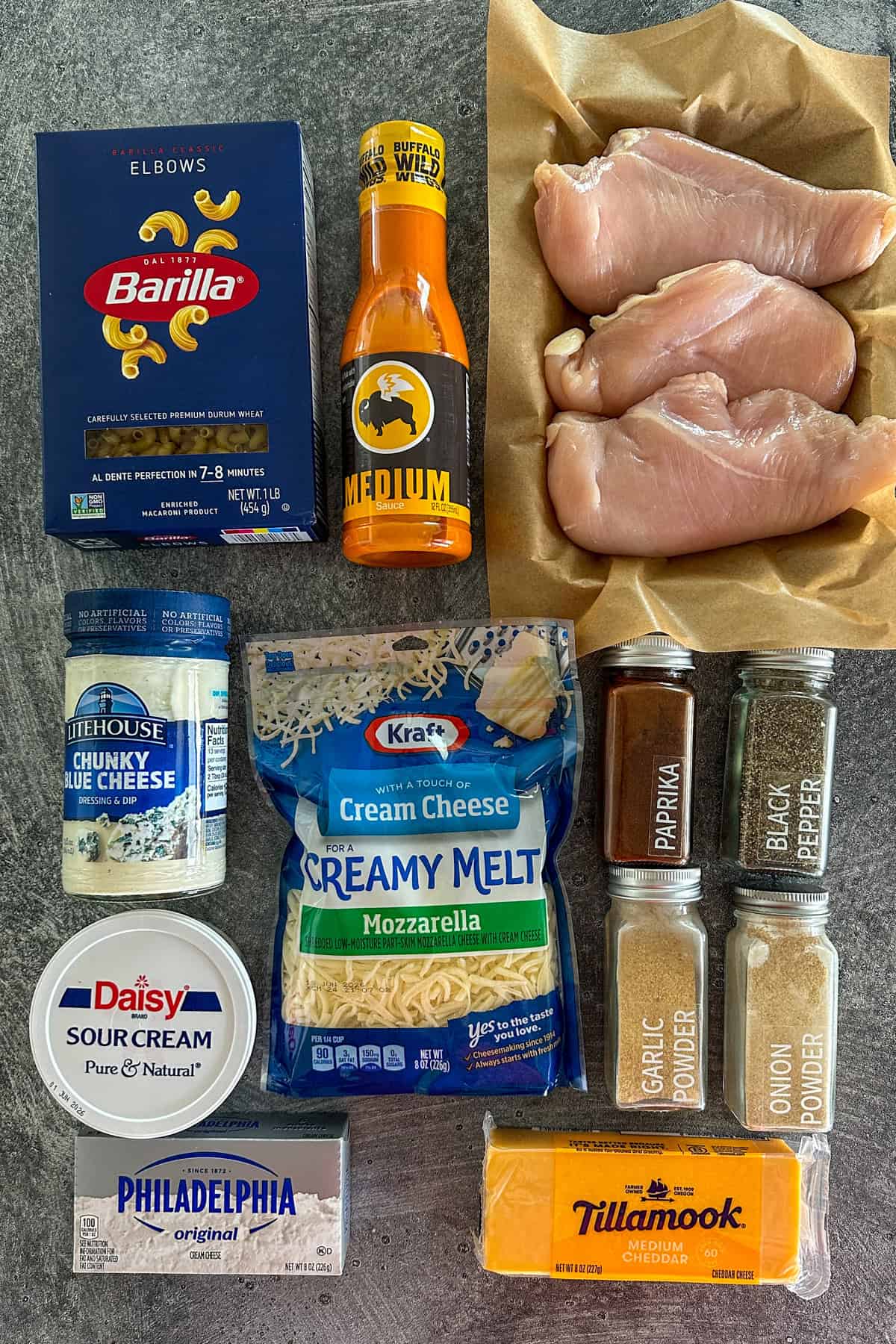 Ingredients to make buffalo chicken mac and cheese on gray countertop.