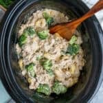 Slow cooker chicken broccoli tortellini with a wooden spoon ready to be served.