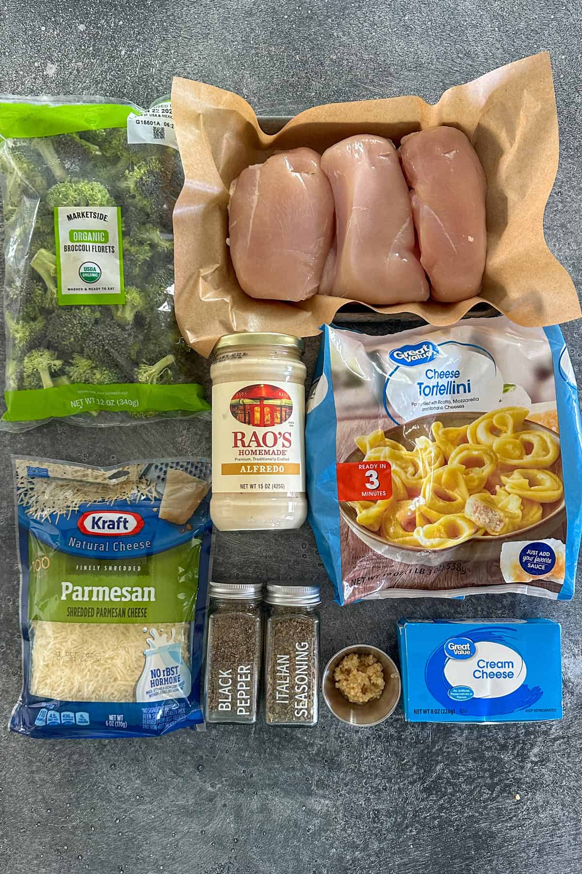 Ingredients to make chicken broccoli tortellini on a stone countertop.